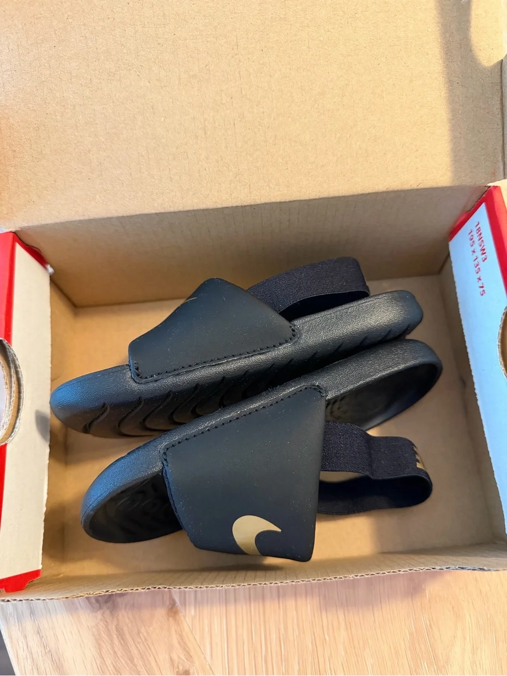 Nike Kids Black Slides with Gold Swoosh and Heel Strap